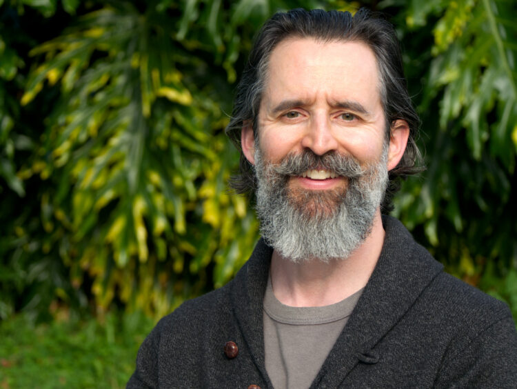 David Kadavy smiling with green plants in the background